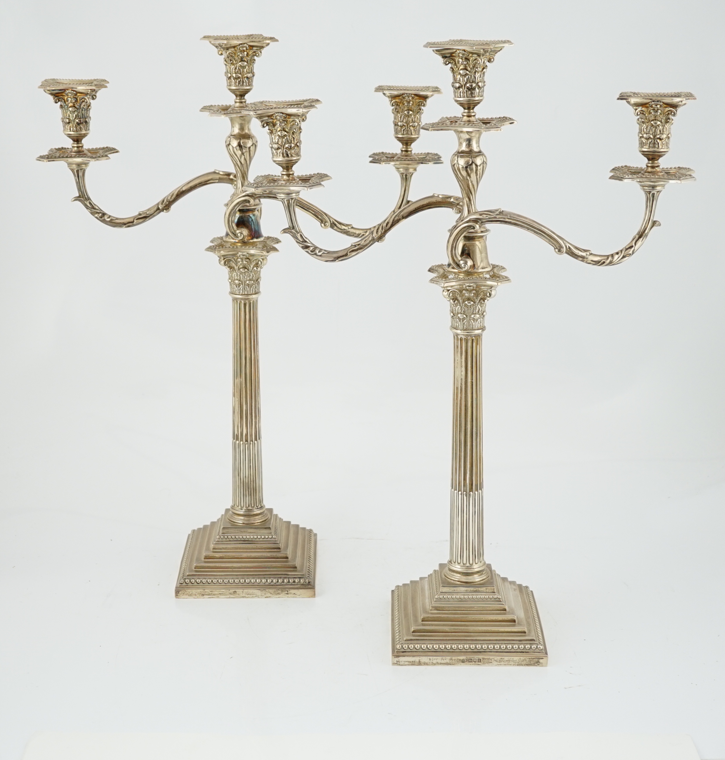 A pair of Edwardian silver two branch, three light Corinthian column candelabra, by William Hutton & Sons